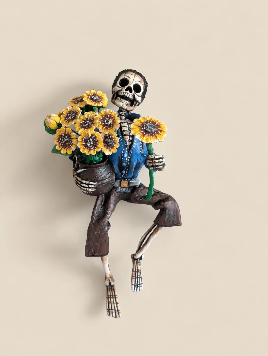 Skeleton figure carrying sunflowers